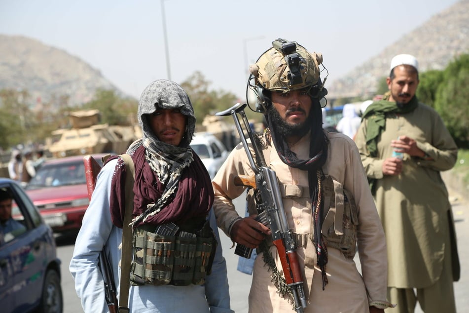Taliban fighters stand guard in Kabul after taking over the city.