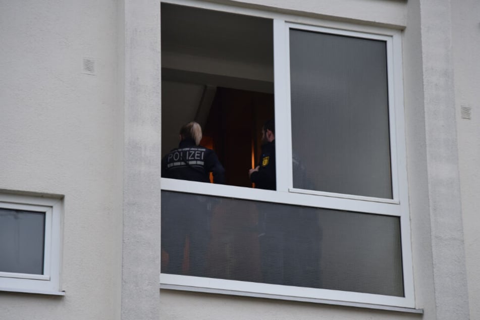 Polizisten im Treppenhaus des Mehrfamilienhauses.