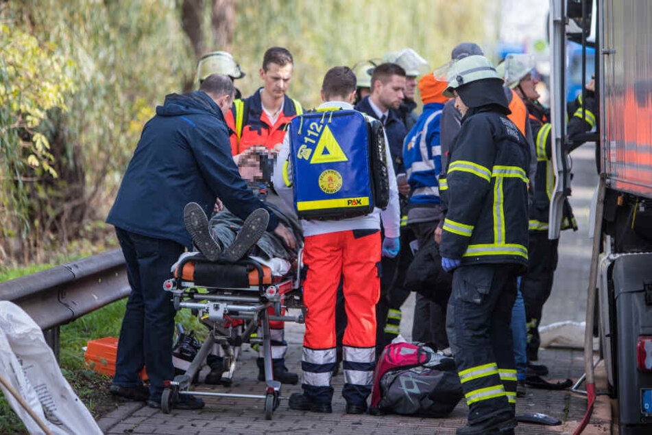 Einer der Fahrer wird von Rettungskräften versorgt.