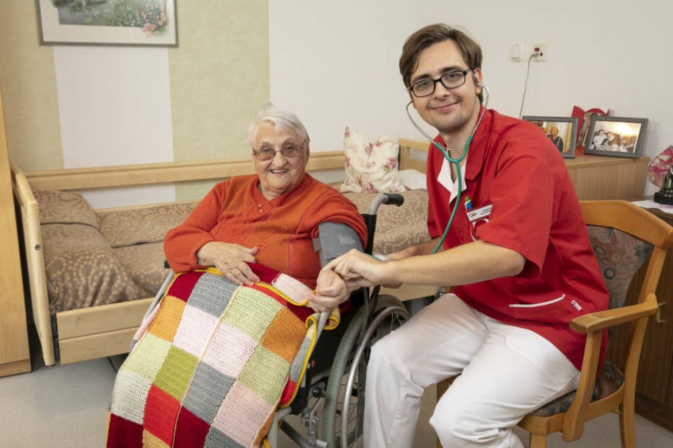 Auf dem Foto rechts Joshua Kasperek (21) Azubi zum Altenpfleger misst gerade den Blutdruck bei Bewohnerin Helga Ludewig (87).