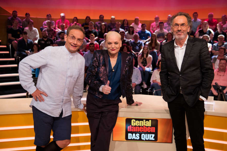 Wigald Boning (l), Hella von Sinnen und Hugo Egon Balder stehen in der Kulisse der Sat.1-Vorabendshow "Genial daneben - das Quiz".
