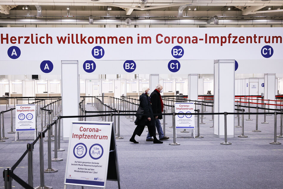 Zwei Senioren gehen durch ein Impfzentrum (Symbolbild).