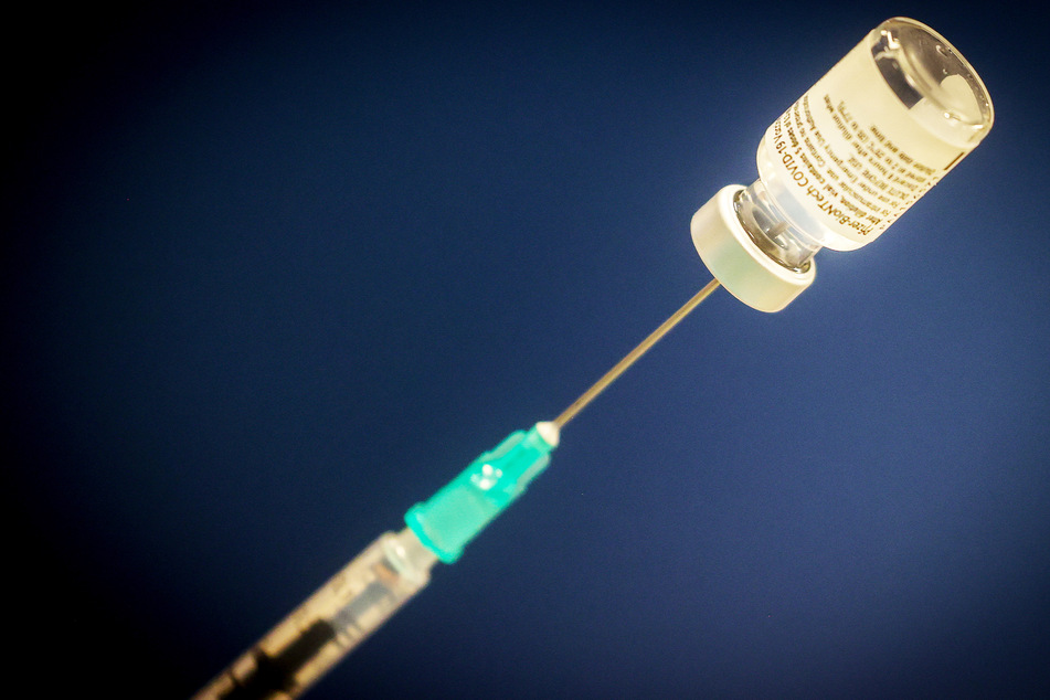 Eine Spritze steckt in einer Ampulle des Corona-Impfstoffes von Pfizer/BioNTech. Dieser wird ab kommender Woche auch ohne Termin in Sachsen verabreicht. (Symbolbild)