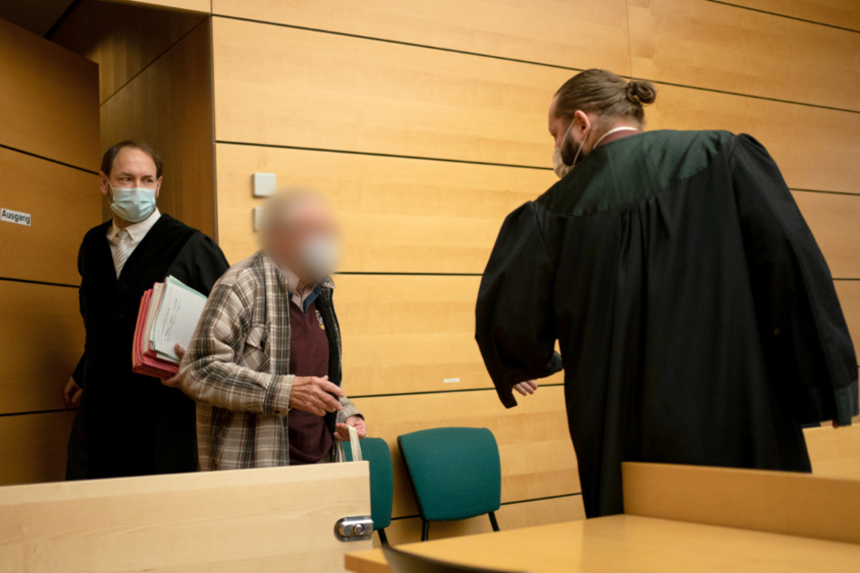 Der Angeklagte (Mitte) wird von seinem Anwalt Norman Jacob (r.) in den Gerichtssaal geführt.
