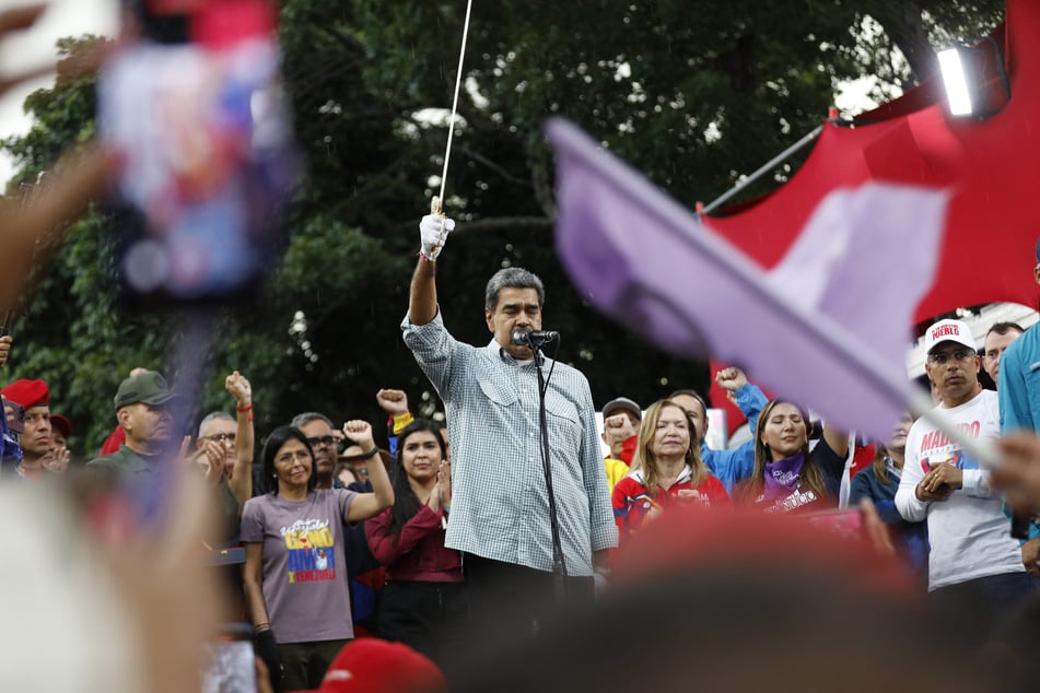 Venezuelan President Nicolas Maduro delivers a speech as he holds a replica of Liberator Simon Bolivar's sword during a rally in Caracas on Saturday. The Venezuelan ruling party called for a mobilization on Saturday, to "celebrate" Maduro's victory, which has been rejected by the US, the European Union, and several countries in the region.