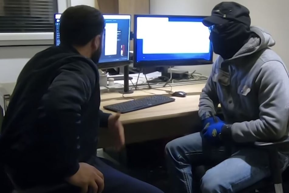 Der Hacker "Kai" (re) erzählt dem Journalisten, wie er vorgeht.