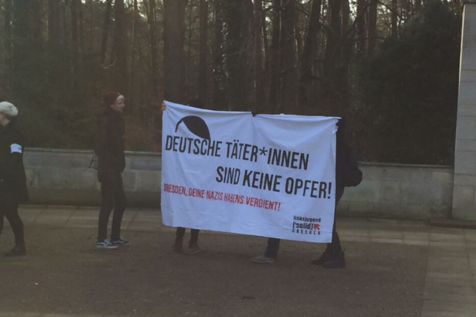 Einige Demonstranten haben sich vor dem Heidefriedhof versammelt.