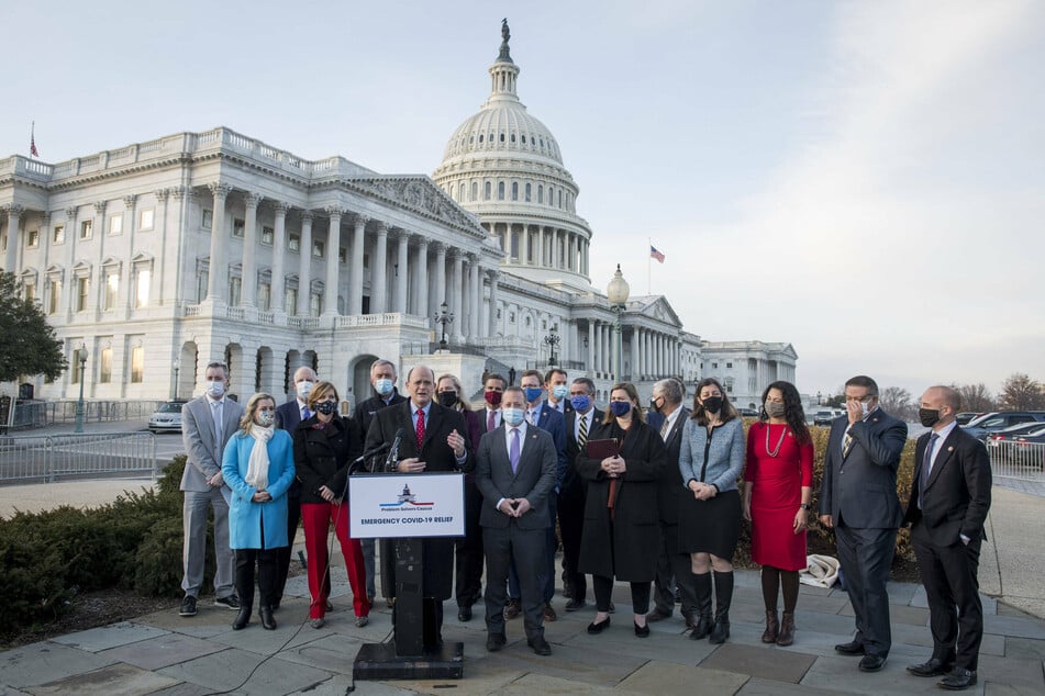 Members of the Problem Solvers Caucus gather outside the US Capitol for a press conference on the current stimulus bill.