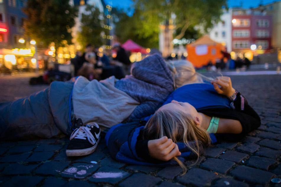 Schüler liegen während des Nachtstreiks auf dem Alter Markt.