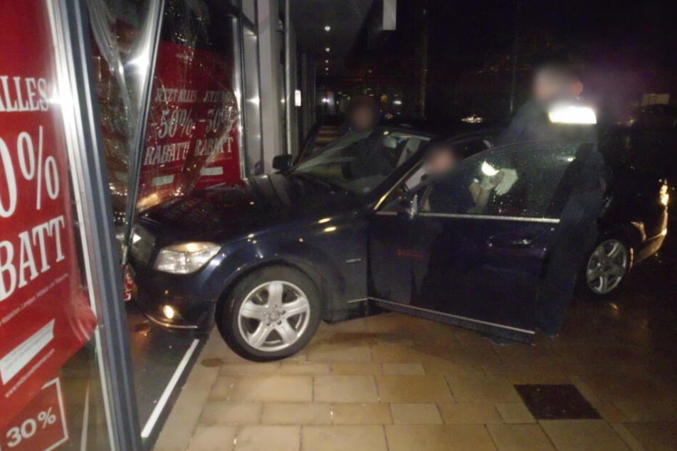 Das Auto krachte in das Schaufenster, die Polizeibeamten versuchten den Mann aus seinem Fahrzeug zu holen.