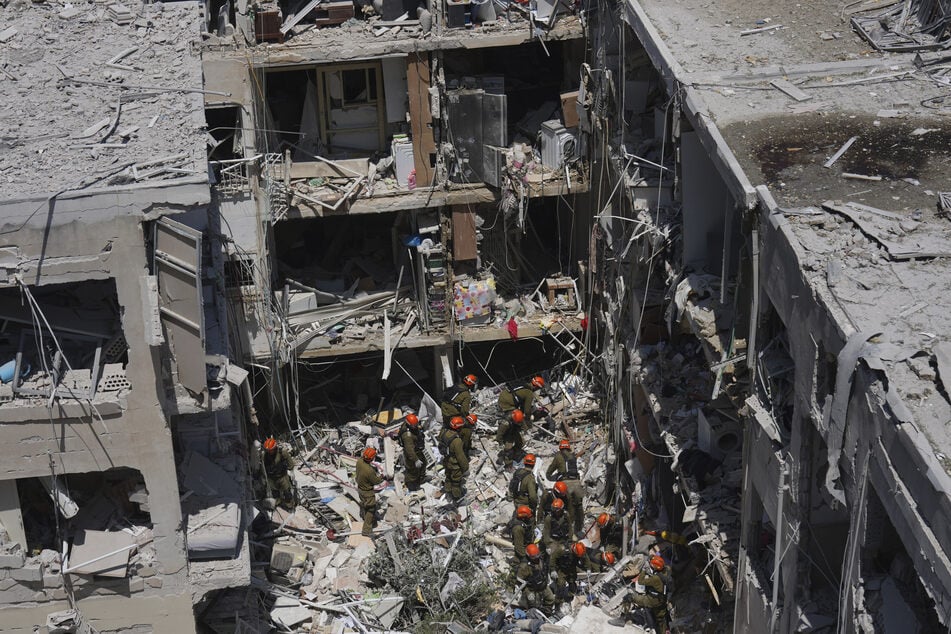 Israelische Soldaten durchwühlen Trümmer, um nach Überlebenden in einem Wohngebiet zu suchen, das von einer aus dem Iran abgefeuerten Rakete getroffen wurde, in Bat Yam, Zentralisrael.