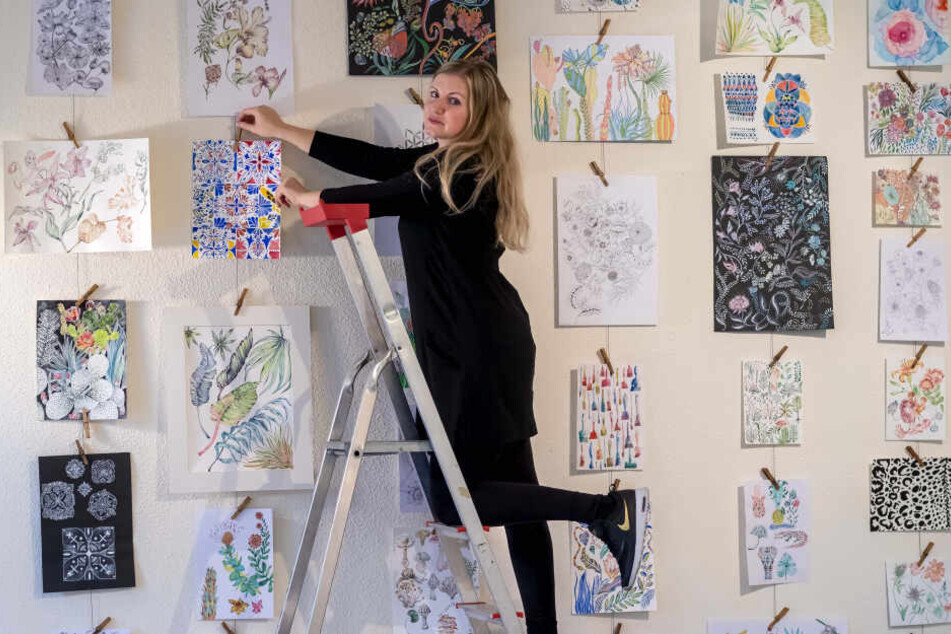 Die Designerin Carolin Tennstaedt (32) hängt ihre Entwürfe im Kulturzentrum "Erzhammer" auf. Manche Designs stammen noch aus ihrer Studienzeit.