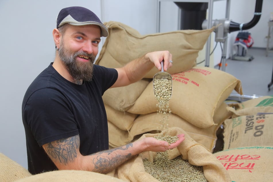 Röster Richter holt die Kaffeebohnen aus dem Sack.