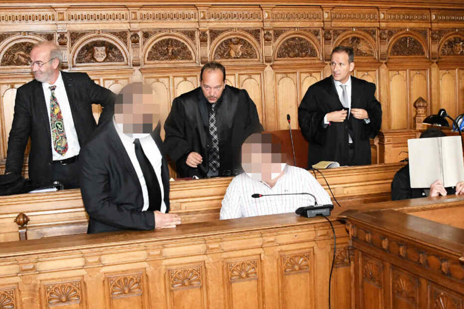 Die drei Angeklagten sitzen bei Prozessbeginn im Landgericht Bremen. (Archivbild)