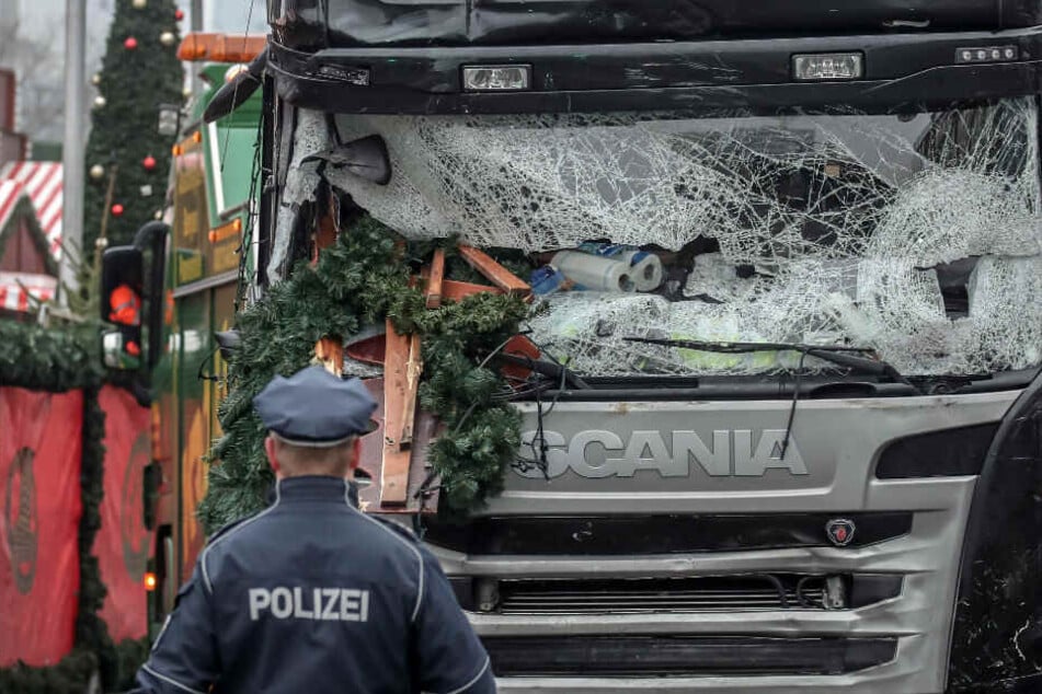 Ein Polizist steht vor dem Lastwagen, mit dem Attentäter Amri über den Weihnachtsmarkt gefahren ist.