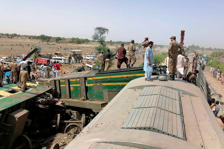 Truppen der pakistanischen Armee und Rettungskräfte sind am Ort der Zugkollision im Einsatz.