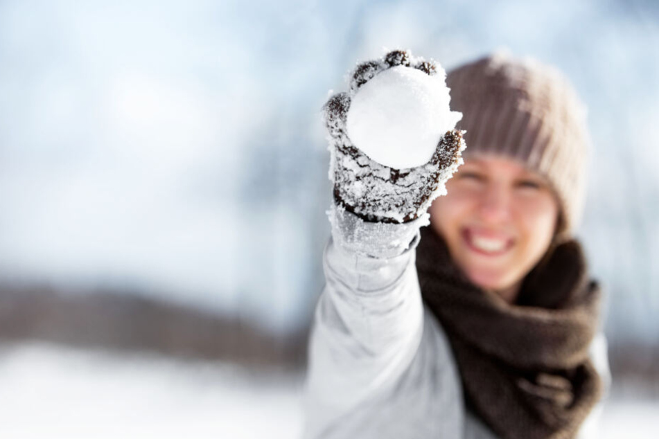 Eine Frau hält einen Schneeball (Symbolbild).