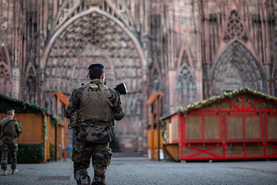 Ein bewaffneter Polizist patrouilliert auf dem Weihnachtsmarkt in Straßburg.