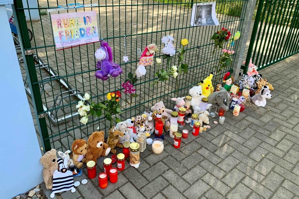 Kinder und Eltern haben zum Gedenken an den verstorbenen Jungen Plüschtiere und Kerzen vor der Kita aufgestellt.