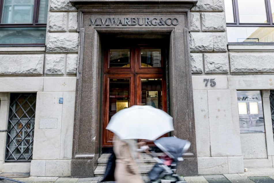 Passanten gehen an der Eingangstür des Bankhauses M.M.Warburg & CO in Hamburg vorbei.
