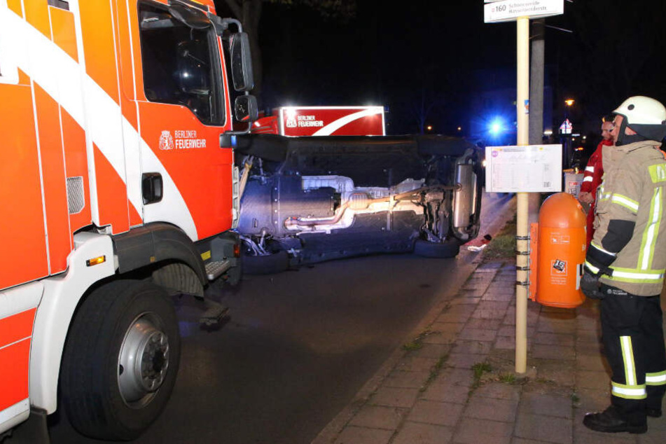 Die Berliner betrachtet das umgekippte Fahrzeug.