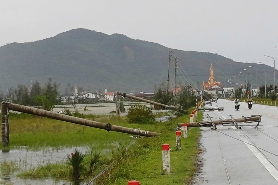 Vietnam, Thanh Hoa: Umgestürzte Strommasten liegen auf der Straße, nachdem der Taifun "Bualoi" über das Gebiet hinweggezogen ist.