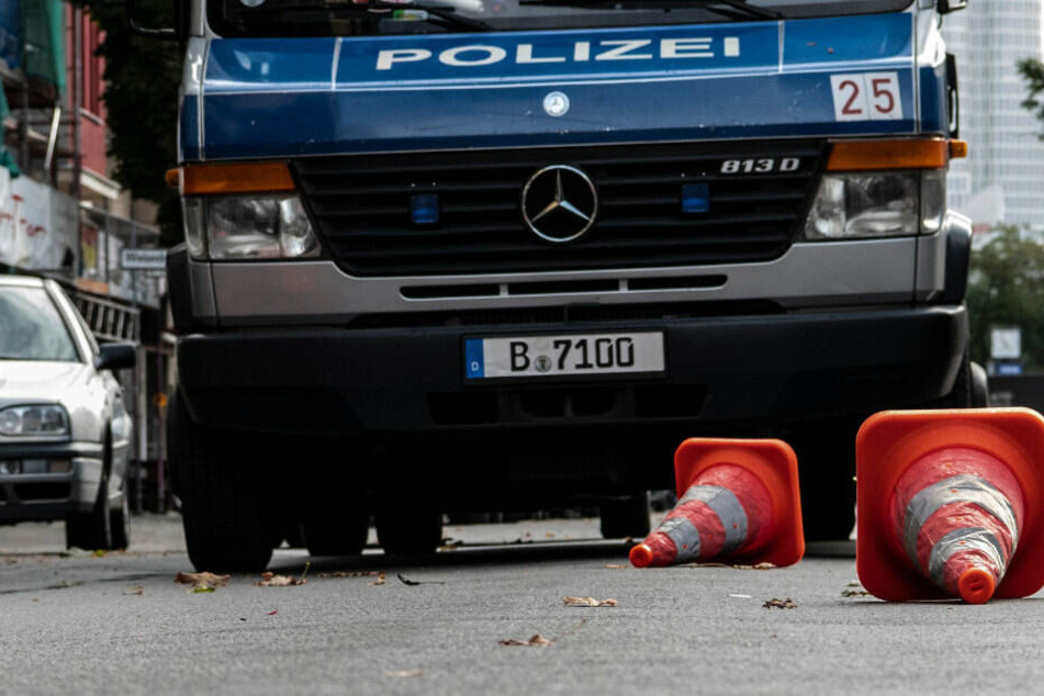 Pylone liegen auf der Kantstraße vor einem Einsatzfahrzeug der Polizei. Die Pylone markieren die Fundorte von Kugeln, nach einer Schießerei in der Nacht.