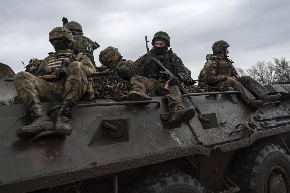 Ukrainische Soldaten fahren mit einem Schützenpanzer in Richtung Frontlinie. (Archivbild)