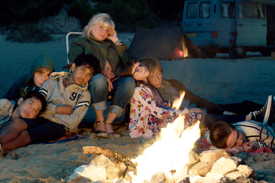 Fahim (Dritter von rechts, Assad Ahmed) und die anderen Kinder des Schachklubs am Abend beim Lagerfeuer am Strand mit Mathilde (M., Isabelle Nanty)