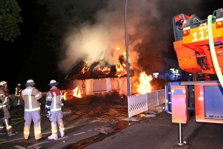 Das Reetdach des Kiosk steht in Flammen.