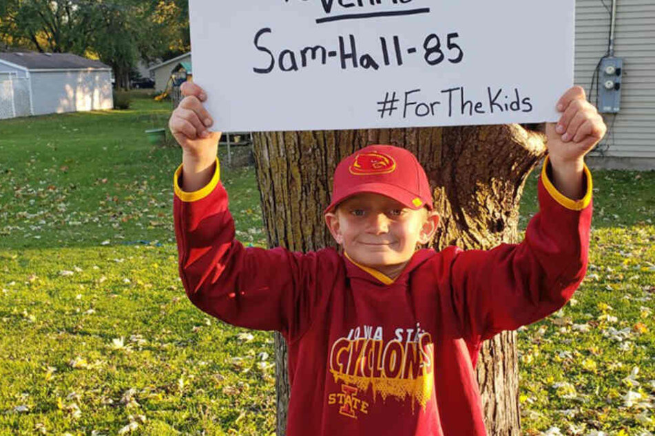 Sam hält stolz sein Schild mit der Spendenkonto-Aufschrift.