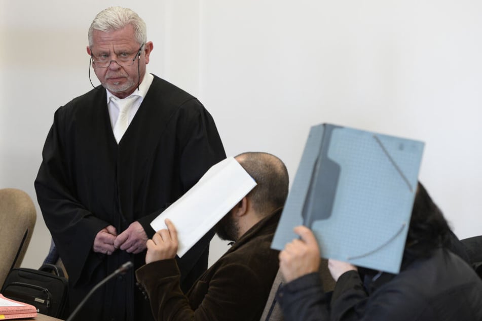 Die Angeklagten warten im Sitzungssaal des Kölner Landgerichts neben Anwalt Dieter Tomczyk auf den Beginn ihres Prozesses.