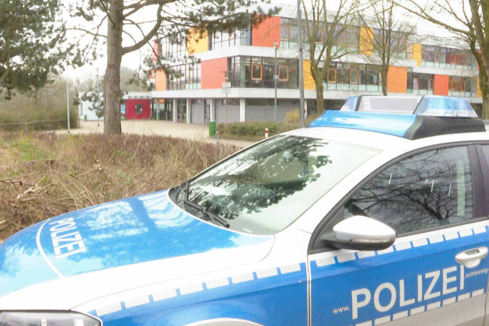 Ein Polizeifahrzeug steht vor der Schule in Glinde.