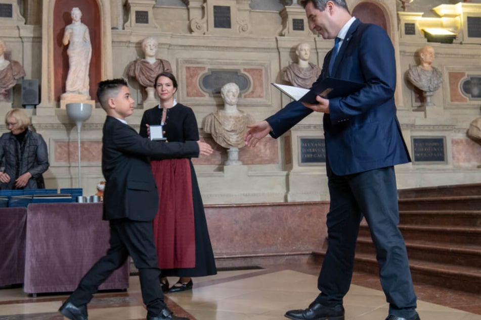 Kenan Büyükhan aus Nürnberg bekommt von Markus Söder (CSU), Ministerpräsident von Bayern, die Christophorus-Medaille überreicht.