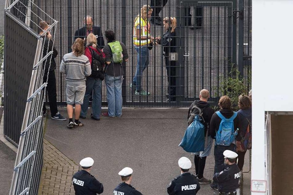 Aktivisten diskutieren mit Polizisten am Eingang zu einem Gate, an dem Flüchtlinge nach Afghanistan Kabul abgeschoben werden sollen.