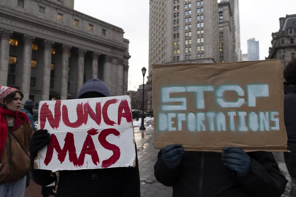 Demonstrators hold signs reading "Stop Deportations" and "Nunca Más" ("Never Again") during a protest against the Trump administration's anti-immigrant platform in New York City.