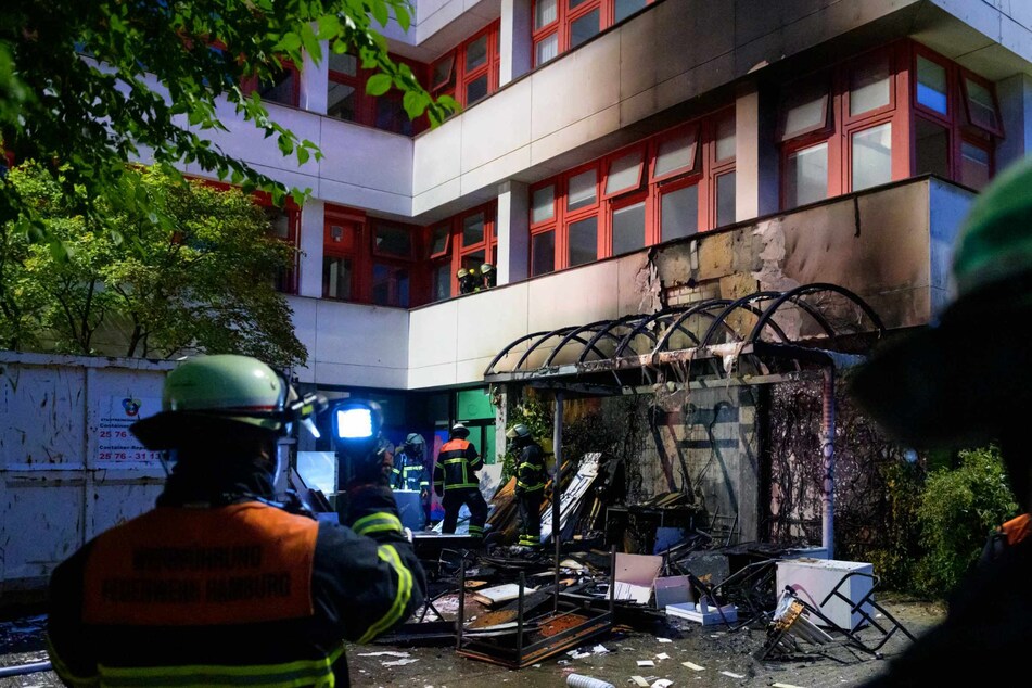 Ein Feuerwehrmann überprüft aus der Ferne die Temperatur am Brandort.