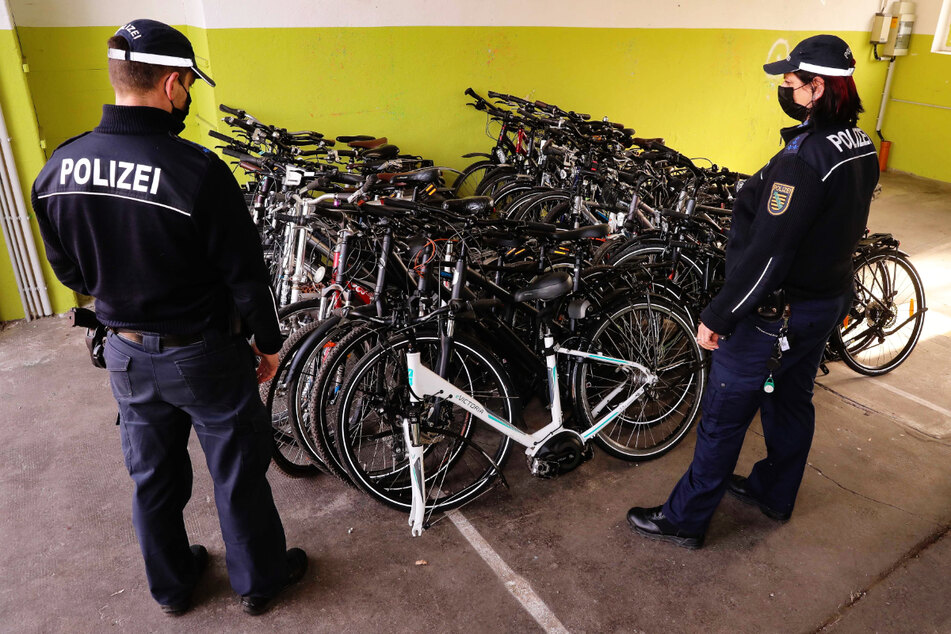 Polizisten stehen vor sichergestellten Fahrrädern. In Leipzig haben sich zahlreiche Beamte an solchen Drahteseln bedient.