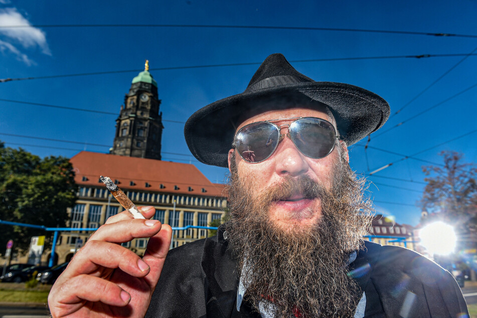 Dissidenten-Chef Max Aschenbach (36, Die PARTEI) mit selbst gedrehter Tüte vor dem Rathaus.