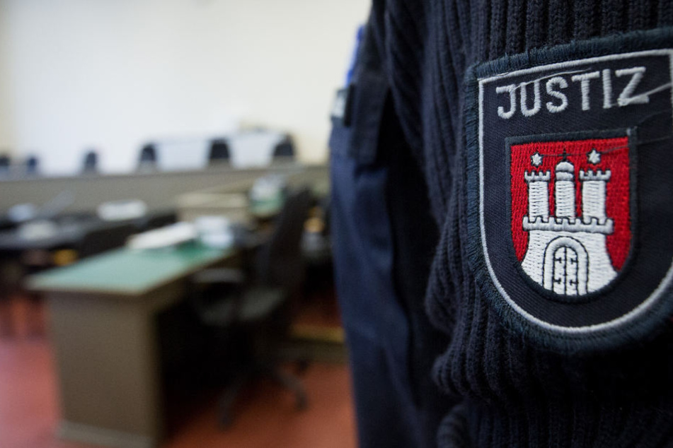 Ein Beamter steht im Verhandlungsraum des Landgerichts.