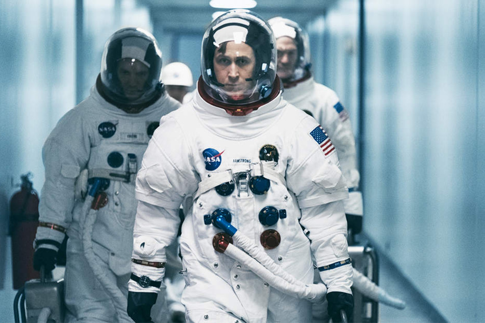 Neil Armstrong (Ryan Gosling, Mitte) mit zwei anderen Astronauten auf dem Weg zu anspruchsvollen Tests.