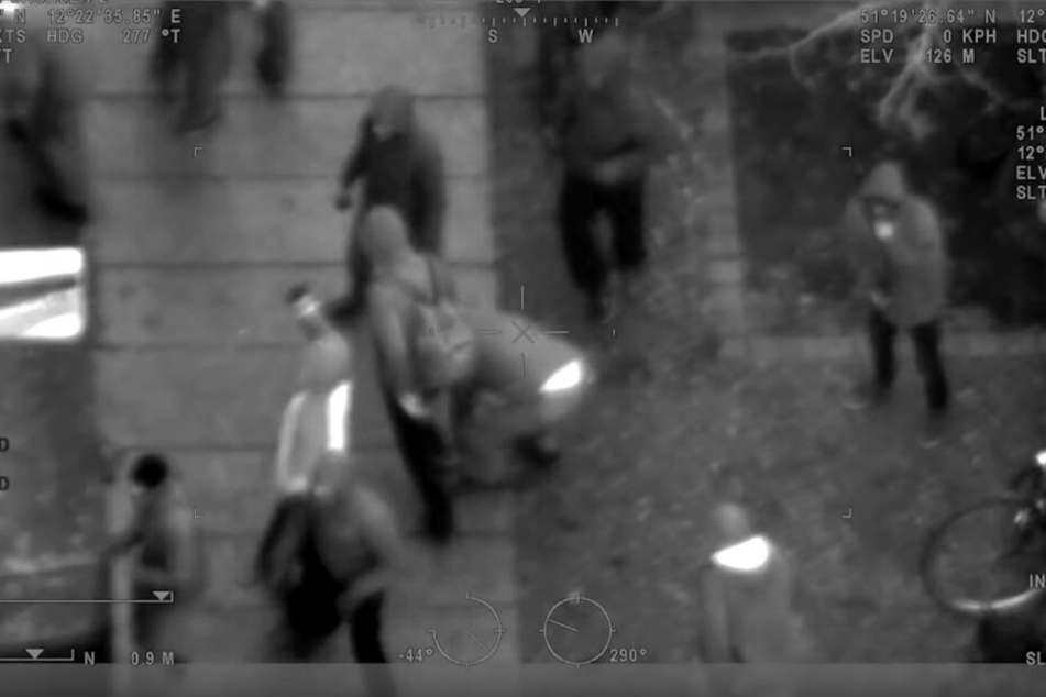 Die Aufnahme stammt aus einem Polizeihubschrauber und zeigt Randalierer, die einen Fußweg aufbrechen, um an Steine heranzukommen.