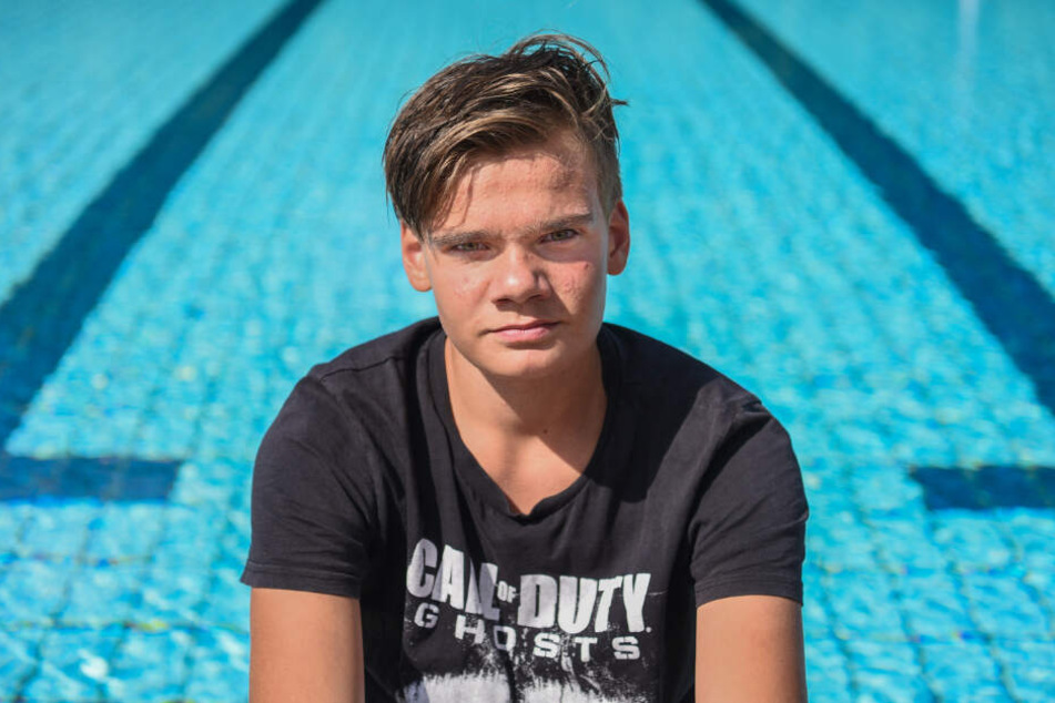 Justin Fischer sitzt am Rande des Nichtschwimmerbeckens im Freibad, wo er einem Vierjährigen das Leben rettete.