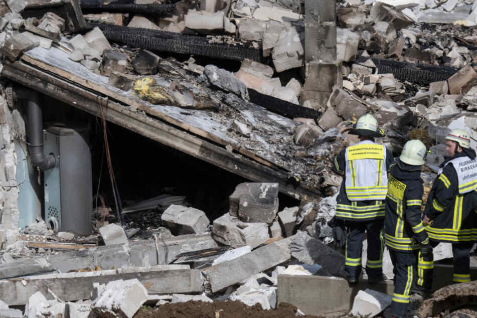 Feuerwehrleute stehen am 22.03.2019 vor den Trümmern des Wohnhauses.