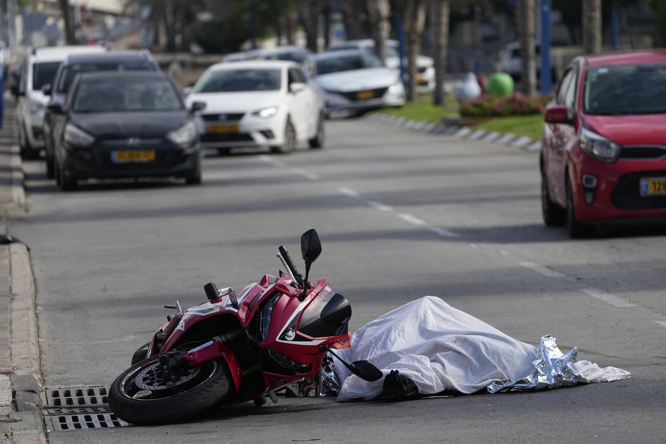 Ein getöteter Zivilist liegt zugedeckt auf einer Straße in Sderot.