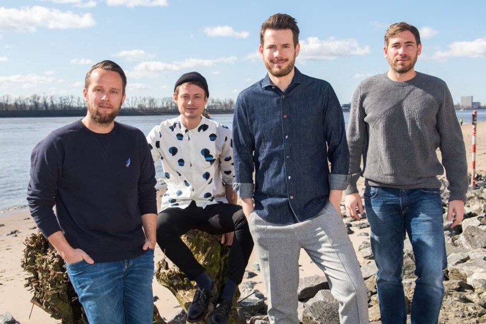 Die Band Revolverheld, bestehend aus Kristoffer Hünecke (l-r), Jakob Sinn, Johannes Strate und Niels Kristian Hansen stehen am Elbstrand.