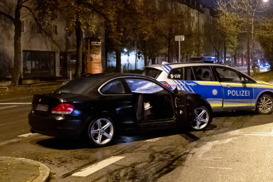 Der beschädigte BMW und ein Polizeiauto stehen am Schicksalsabend in der Fürstenrieder Straße in München.
