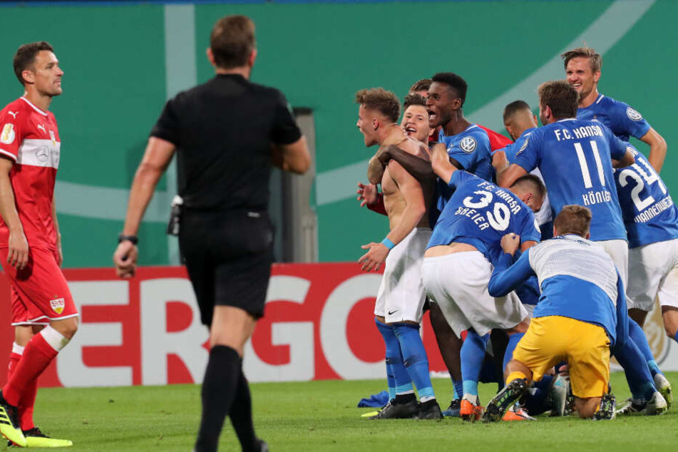 Die Rostocker feiern den Torschützen zum 2:0 Mirnes Pepic (nackter Oberkörper), rechts der Stuttgarter Christian Gentner. Der Drittligist besiegt den Erstligisten aus Stuttgart mit 2:0 (1:0).