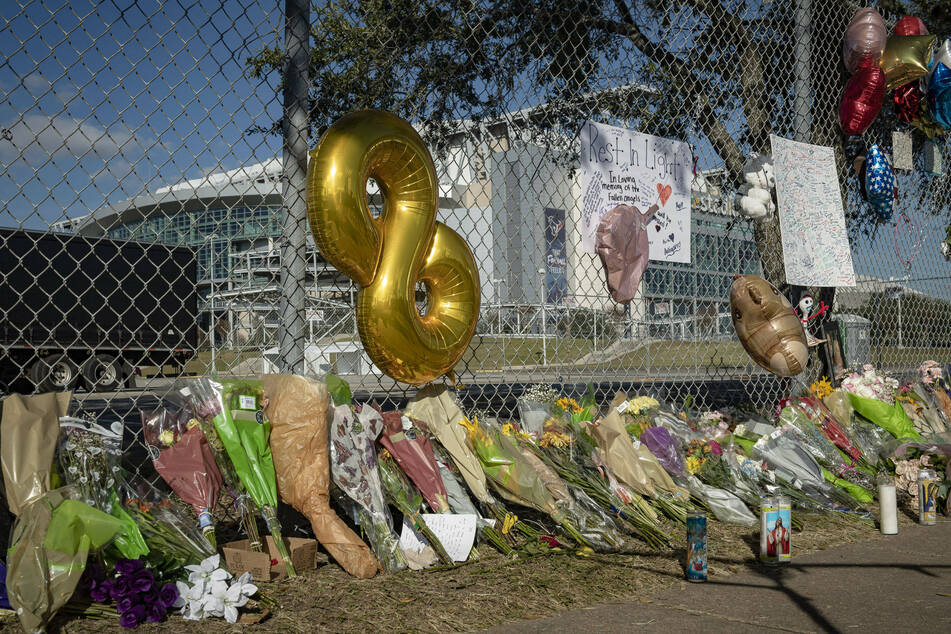 Candles, flowers, and letters are placed at a memorial outside Houston's NRG Park.