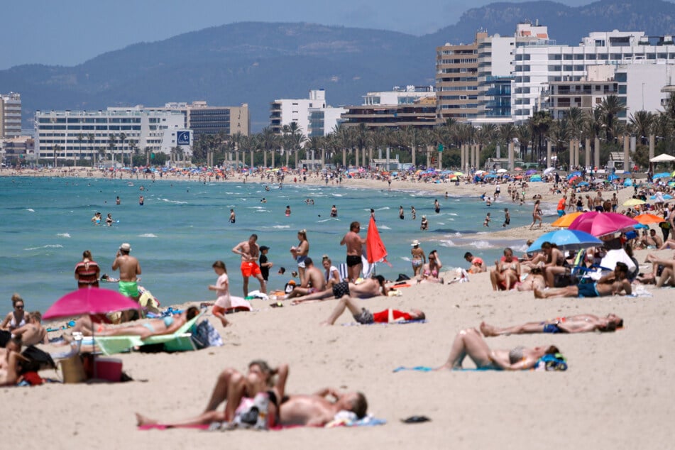Spanien, Mallorca: Menschen sonnen sich am Strand von Arenal.